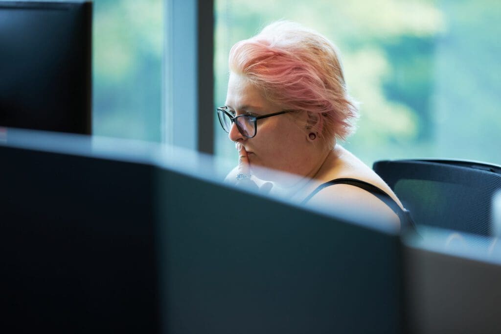 A woman concentrates while looking at a computer screen