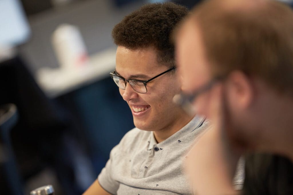 A man smiles in a conversation