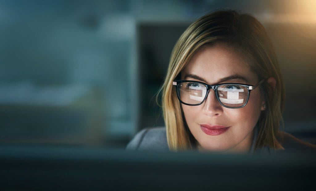 A woman focuses on a computer screen