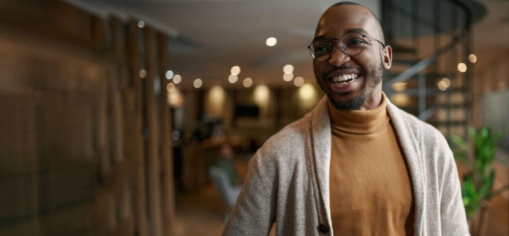 A man smiles in a modern workplace