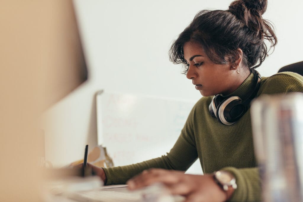 A women is concentrated and writing notes
