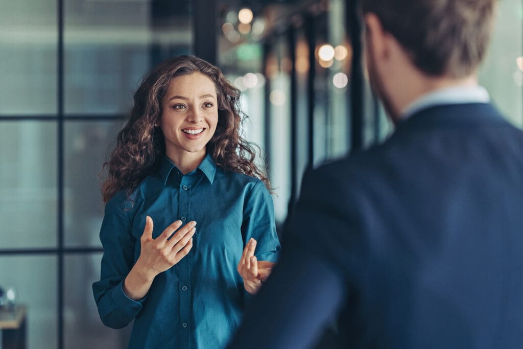 A woman smiles at a man as they have a conversation