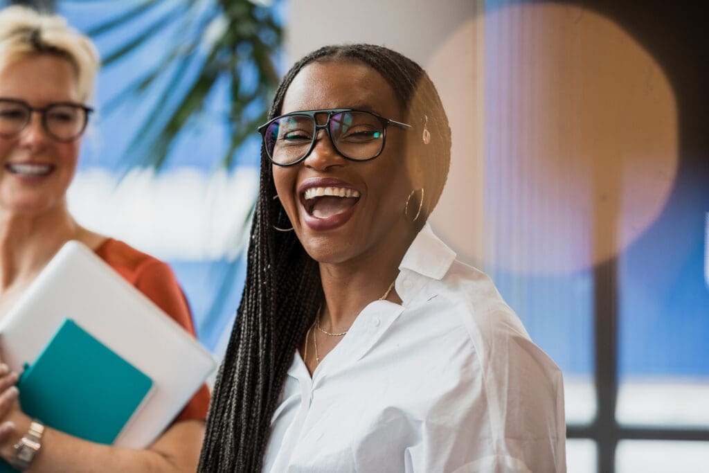 A woman smiles widely with her colleagues