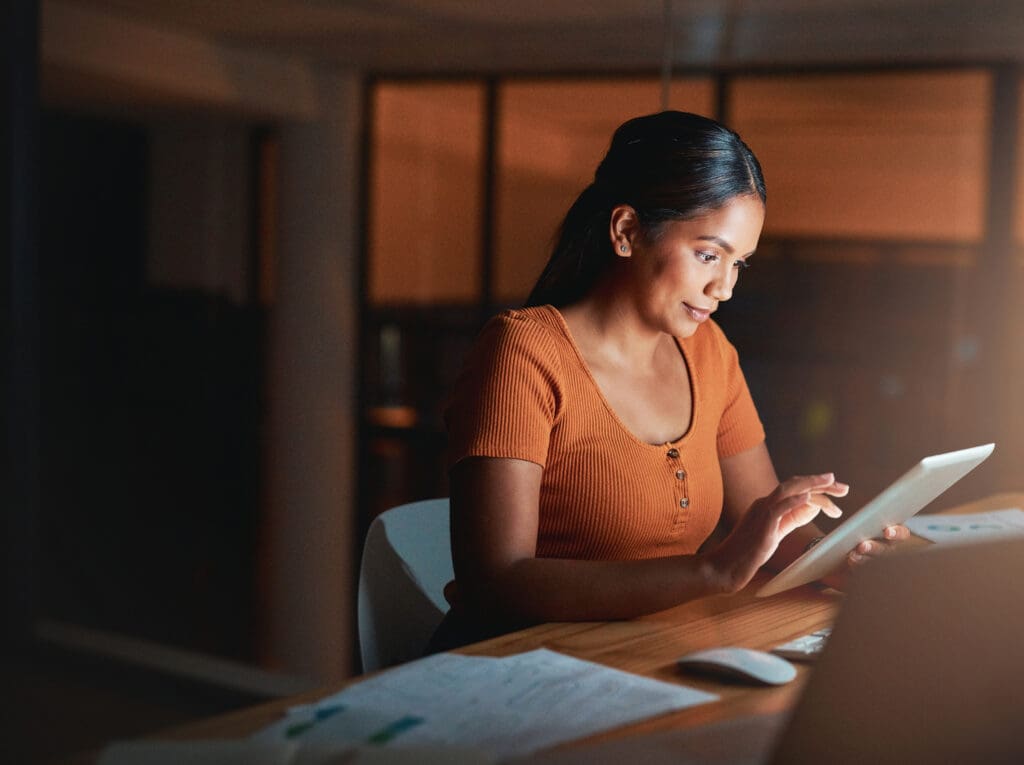 A women looks thoughtfully at a tablet screen